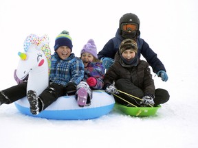 The smiles and giggles were obvious as Miles Linton (left), 8; his sister Grace, 6; Matteo Valentino, 11 and brother Marco (in helmet), 8, all of Mitchell soar down the Mitchell Lions Pool hill on Jan. 29. They weren't the only ones enjoying the outdoor fun, as the hill proved a popular place all weekend.  ANDY BADER/MITCHELL ADVOCATE
