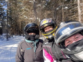Brighite Aitken (left), Lee-Ann Ruston and Katie Schellenberger stop at the side of a snowmobile trail recently, enjoying the sport like many other people this winter. SUBMITTED