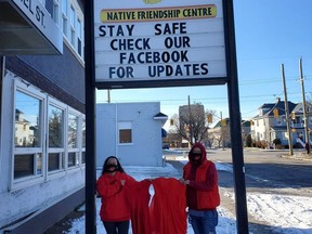 Deborah Munroe, left, and Barbara Golder with the Sarnia-Lambton Native Friendship Centre pose with red dresses going on display in Sarnia Feb. 14 as part of a Women's Memorial March event. (Submitted)