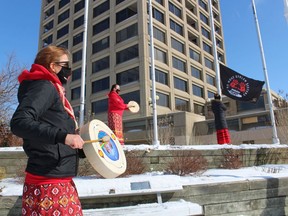 From left, Gillian Farrell, Heather MacDonald and Marina Plain take part Sunday in a flag-raising ceremony at the Sarnia waterfront to remember missing and murdered Indigenous women from across Canada.