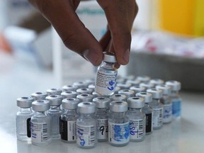 A health-care worker handles vials of Pfizer/BioNTech vaccine. Dr. Lyle Melenka, a Sherwood Park respiratory physician, has offered Synergy Respiratory and Cardiac Care as a vaccine storage and inoculation site to Alberta Health.  IVAN ALVARADO/REUTERS