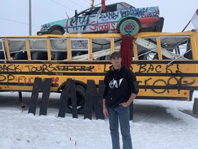 Skyler Williams, spokesperson for 1492 Land Back Lane, stands in front of a bus that has served as a barricade across Argyle Street in Caledonia for four months. The barricades were scheduled to come down Monday. VINCENT BALL