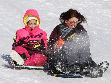 Nancy Parnell slides down a hill at Bell Park in Sudbury, Ont. with her children, Claire and Collin, on Wednesday February 3, 2021. John Lappa/Sudbury Star/Postmedia Network