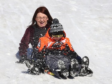Nancy Parnell slides down a hill at Bell Park in Sudbury, Ont. with her son, Collin, 8, on Wednesday February 3, 2021.