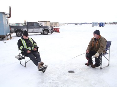 Richard Tranchemontagne, left, and Denis Lachapelle enjoy some conversation while ice fishing near their huts on Whitewater Lake in Azilda, Ont. on Thursday February 4, 2021. John Lappa/Sudbury Star/Postmedia Network