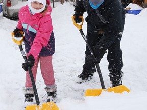 Selena Wuthrich-Giroux, 9, and her brother, Oliver, 14, clear snow off their driveway in Gatchell on Friday February 5, 2021.
