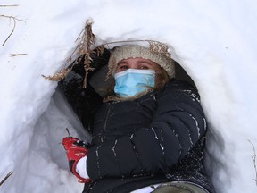 Jennifer Beaudry pulls snow out of the entrance of a quinzhee during a Grade 11 outdoor activities class at Lockerby Composite School in Sudbury, Ont. on Monday February 8, 2021.