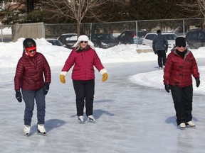 Peg Scherzinger, left, Ann Frampton and Colleen Fraser glide along the ice at Queen's Athletic Field skating oval in Sudbury, Ont. on Friday February 12, 2021.