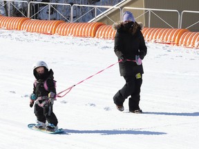 Dana Cuddy keeps a watchful eye on her daughter, Tori, 3, as the little one learns to snowboard at Adanac Ski Hill in Sudbury, Ont. on Wednesday February 17, 2021.