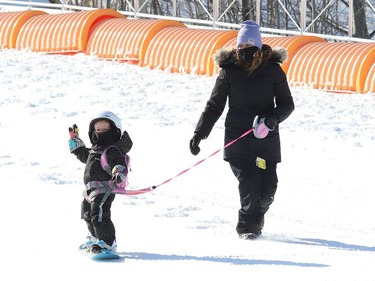 Dana Cuddy keeps a watchful eye on her daughter, Tori, 3, as the little one learns to snowboard at Adanac Ski Hill in Sudbury, Ont. on Wednesday February 17, 2021. Both Adanac and Lively Ski Hill opened for the season on Wednesday. Operations have been adapted in response to COVID-19. Patrons must book their tickets before arriving at either ski hill, as day tickets will not be available onsite. Those with memberships or punch cards are also required to book ahead. Booking can be done online at www.greatersudbury.ca/leisure. John Lappa/Sudbury Star/Postmedia Network