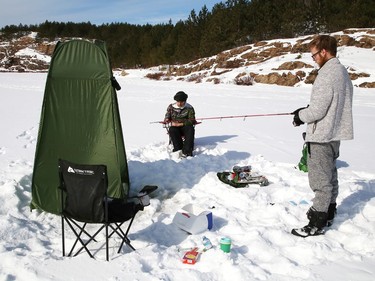 Joel Lapierre, right, and his son, Donald Wade, spent the afternoon ice fishing at Lake Laurentian in Sudbury, Ont. on Thursday February 18, 2021. John Lappa/Sudbury Star/Postmedia Network