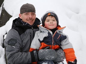 Kurt Fraser and his son, Zack, 4, sit on the youngster's favourite rock in Sudbury, Ont. on Monday February 22, 2021. John Lappa/Sudbury Star/Postmedia Network