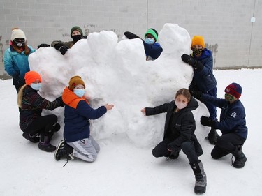 Grade 6 students at Ecole St-Denis work on a snow sculpture at the school in Sudbury, Ont. on Tuesday February 23, 2021. Students took advantage of the fresh snow to build sculptures and snow people around school grounds. John Lappa/Sudbury Star/Postmedia Network