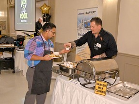 BDO's Jason Harris (right) serves Personal Touch Catering's Paresh Thakkar at Huron House Boys' Home's annual Men Who Cook fundraiser on March 7, 2020. This year, due to the pandemic, Huron House will be holding a new, curbside pickup fundraiser, Staying Home for the Boys' Home event on March 6.  Handout/Sarnia This Week