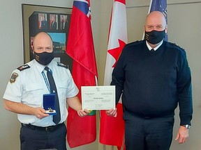 Timmins Police Service Staff Sgt. Tim Chalmers, left, was presented with a 20-year service pin, a uniform ribbon and a scroll from the Governor-General from Timmins Police Chief John Gauthier. Chalmers was being recognized for his two decades of service with TPS.

Supplied