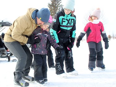 Alexa Jordaan gets a helping hand from Matt Harasy, learning to skate at the Hollinger Skating Path on Monday. 
Looking on is Ellie Therrien, on far right, and her sister Mia.

RICHA BHOSALE/The Daily Press