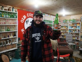 Ryan Devion shows off his favourite bottle in his collection, a 7UP bottle that was bottle by the Silver Lake Beverage Company in Kenora.