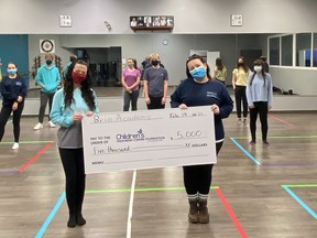 Brittany DeJoseph, dance instructor at Brio Academy, and Rachel Schwarz, founder and artistic director hold up a cheque for $5,000 to the Children's Treatment Centre Foundation of Chatham-Kent in front of the teen musical theatre performance team. The academy held a virtual fundraiser in December featuring performances from the students. (Handout/Postmedia Network)