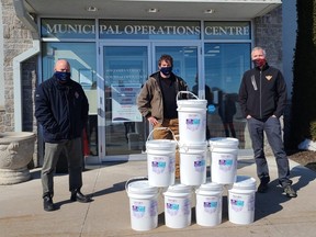 Ray Cousineau, Town of St. Marys facilities supervisor (left), and St. Marys Mayor Al Strathdee accept a donation of 160 litres of hand sanitizer from Canadian Tire franchisee Daniel Lubimcev. (Contributed photo)