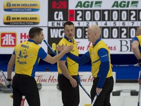 Second John Morris (left) and skip Kevin Koe shake hands after defeating Brad Gushue's Team Canada 9-7 on Sunday. PHOTO BY MICHAEL BURNS PHOTO /Curling Canada