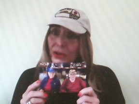 Lucinda Allaer holds a photograph of her father George, 88, on the right, and her late uncle Frank, while taking part in protest calling for more action by the Ontario government to address the crisis in long-term care that was live-streamed on the Ontario Health Coalition Facebook page on March 3. Ellwood Shreve/Postmedia Network