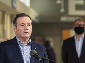 Premier Jason Kenney speaks at a press conference while Health Minister Tyler Shandro stands beside him at Crowfoot CO-OP in Calgary on Tuesday, March 2, 2021.
