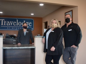 Travelodge front desk clerk Carleen Smyke (from left to right), Manager Brigette Lawson, and owner David McQuaig stand in the lobby of the newly purchased hotel.