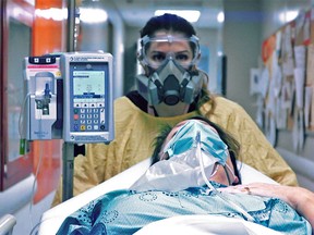 Registered nurse Sarah Cormier moves Quinte Health Care board member Lisa O'Toole, posing as a patient, during a training exercise. The corporation's first patient with a confirmed COVID-19 infection arrived March 23, 2020.