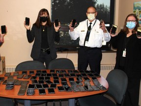 Some of the surplus cell phones that will be used by clients of Victim Services of Bruce, Grey and Perth were displayed March 19  displayed March 19 by Ashley Anderson (left) - OPP West Region HQ administrative assistant, Victoria Loucks - Staff Sergeant West Region Abuse Issues, Victim Response Support Unit, Chief Superintendent Dwight Thib - OPP WR Commander and Dawn Orr - OPP WRHQ assistant. OPP Photo