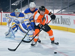 Travis Konecny (11) of the Philadelphia Flyers and Henri Jokiharju (10) of the Buffalo Sabres battle for the puck in front of Sabres goalie Carter Hutton in the first period at Wells Fargo Center on January 19, 2021, in Philadelphia, Pennsylvania. (Photo by Drew Hallowell/Getty Images)