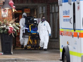 Health-care activists say the province didn't do enough. Essex-Windsor EMS paramedics are shown taking a patient to hospital from The Village at St. Clair long-term care home in Windsor on Dec. 16, 2020.