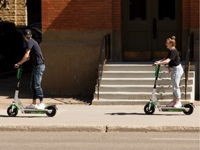Two riders try out Lime electric scooters along 101 Street in Edmonton when they launched in August 2019. Lime scooters returned to Edmonton streets Wednesday for the third straight year.