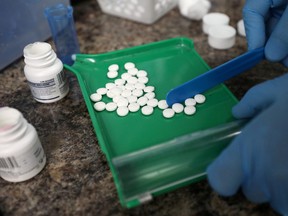 A pharmacist counts prescription drugs. PHOTO BY Chris Wattie/REUTERS