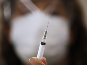 LoriAnn Laramee, public health nurse, prepares dilutant for the COVID-19 vaccine in the COVID-19 vaccination clinic at the Health Sciences Centre in Winnipeg, Wednesday, December 16, 2020. Qualified Manitobans received their first inoculation in the COVID-19 vaccination. THE CANADIAN PRESS/John Woods