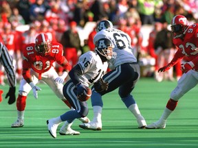Offensive tackle Chris Schultz provides the blocking as Argonauts' quarterback Matt Dunigan rolls out against the Stampeders during the 1991 Grey Cup in Winnipeg.