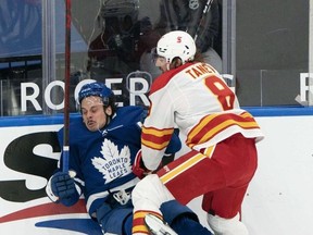 Toronto Maple Leafs centre Auston Matthews (left) battles along the boards with Calgary Flames defenceman Christopher Tanev at Scotiabank Arena last night.  USA TODAY