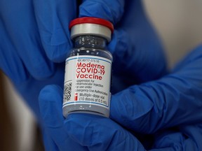 An employee shows the Moderna coronavirus (COVID-19) vaccine.