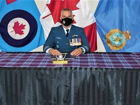 Lieutenant-Colonel Tony Johnson, left, is joined by Colonel Ryan Deming, 8 Wing Commander, as he takes command of 2 Air Movements Squadron from LCol Brandon Sing during a small socially-distanced signing ceremony at 8 Wing Trenton Thursday. DND