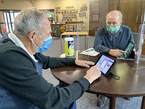 Fairview United Church member Gord Ferrell (left), 94, gets lessons on using an iPad from Tom Smiley as the church is providing the devices to help their members stay connected and watch virtual worship services.