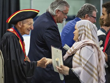 Walter Gretzky congratulates a woman during a citizenship ceremony on Canada Day, July 1, 2017 in Brantford, Ontario.