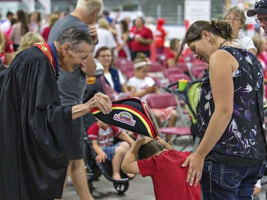 Brantford's Lord Mayor Walter Gretzky tries to put his hat on a shy youngster following citizenship ceremonies on Canada Day, July 1, 2017 in Brantford, Ontario.