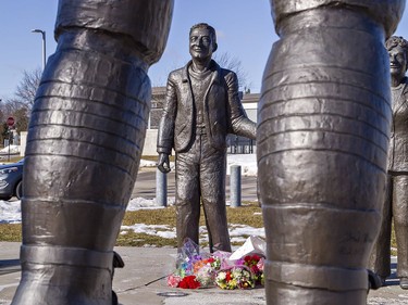 Floral tributes lay at the feet of a statue of Walter Gretzky outside the Wayne Gretzky Sports Centre in Brantford, Ontario. With it is one of his wife Phyllis, and Wayne Gretzky as a youngster, looking up at a larger statue of Wayne Gretzky hoisting the Stanley Cup over his head. Walter Gretzky passed away Thursday at his Brantford home at the age of 82. Brian Thompson/Brantford Expositor/Postmedia Network