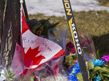 Hockey sticks and floral tributes lay on the front lawn of Walter Gretzky's home in Brantford, Ontario on Friday March 5, 2021. Canada's favourite hockey dad passed away at home Thursday at the age of 82. Brian Thompson/Brantford Expositor/Postmedia Network