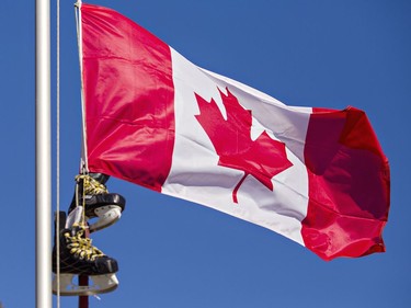 Brantford resident Randy Papple hoists a hockey stick and pair of skates up his flag pole on Friday as a tribute to Walter Gretzky. Brian Thompson