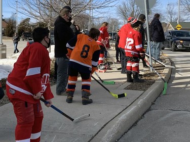 Children lining Walter Gretzky Boulevard hit their hockey sticks on the sidewalk as Gretzky's funeral procession enters the Wayne Gretzky Sports Centre on Saturday, March 6. MICHELLE RUBY/BRANTFORD EXPOSITOR