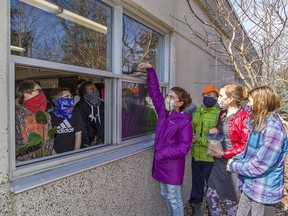 Rachel Brown, age 11 adds birdseed to the window feeder at Port Rowan Elementary School on Monday March 8, 2021. The Long Point Biosphere Reserve has provided FeederWatch kits to 50 classrooms in Haldimand and Norfolk counties. Grade six classmates with her outside are Josh Hunt, Joelle Plumley and Avery Block (right).