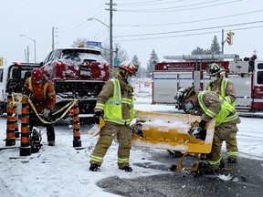 Brockville firefighters pick up a traffic signal that fell to the pavement after a collision at the intersection of Stewart Boulevard and Parkedale Avenue on a snowy Saturday morning.A 27 year old man was charged with failing to stop at a red light. There were no injuries. (RONALD ZAJAC/The Recorder and Times)