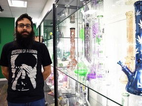 Greg Kazarian, president and chief financial officer of Higher Limits Cannabis Company, stands next to a bong cabinet in the company's Chatham cannabis store March 5, 2021.