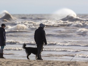 Jenny Lang and Zach Vandenbroek of Port Stanley, out dog-walking, enjoy the views of breaking waves on Lake Erie at Port Stanley's main beach in this photo from January 2021. Mike Hensen/Postmedia Network