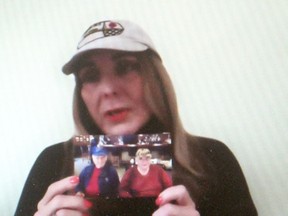 Lucinda Allaer holds a photograph of her father George, 88, on the right, and her late uncle Frank, while taking part in protest calling for more action by the Ontario government to address the crisis in long-term care that was live-streamed on the Ontario Health Coalition Facebook page Wednesday. (Ellwood Shreve/Chatham Daily News)